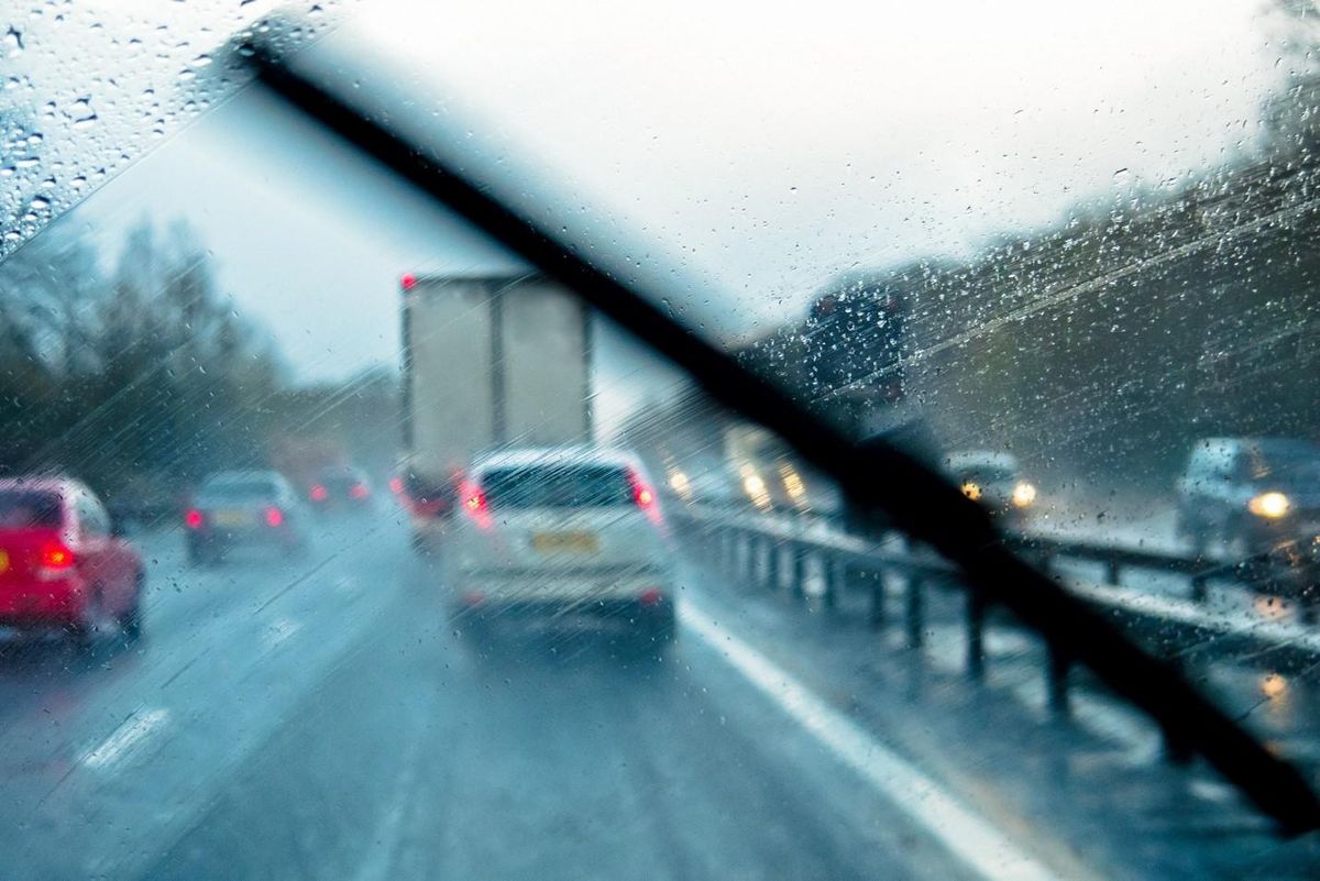 View of highway traffic through rainy windshield