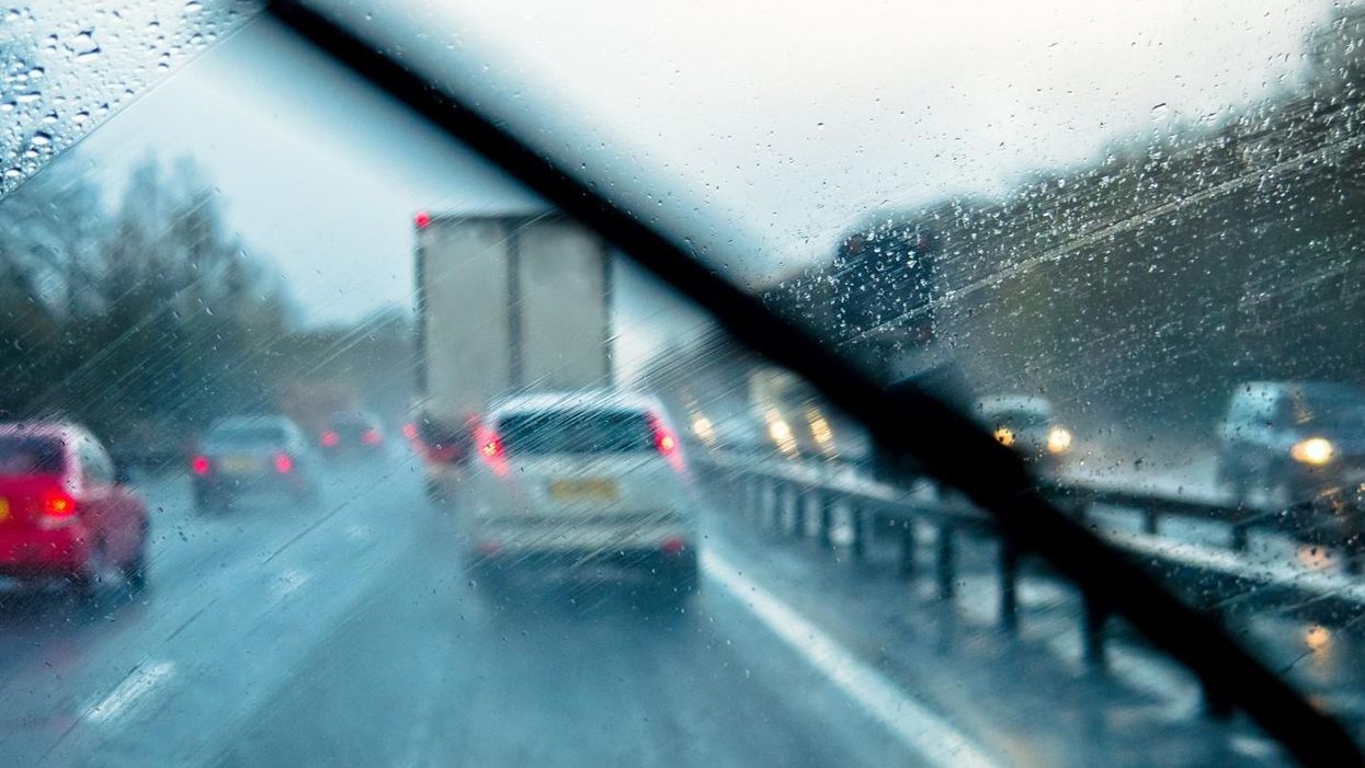 View of highway traffic through rainy windshield
