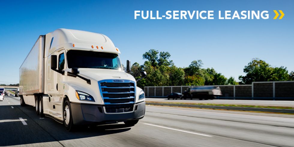 White semi-truck on highway with "Full-Service Leasing" text above.